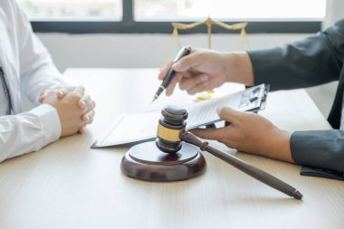 Hakim tokmağı erkek avukatın önünde duruyor. İş anlaşmazlığına danışma hizmeti veriyor..