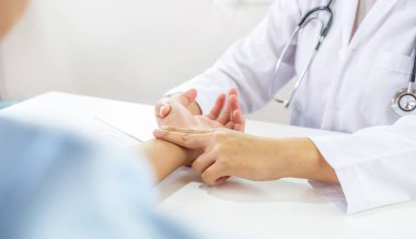 Doktor el hastanın nabzını kontrol eder ve sonuçları kaydeder. Sağlık kontrolü konsepti..