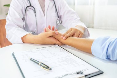 Doktor el hastanın nabzını kontrol eder ve sonuçları kaydeder. Sağlık kontrolü konsepti..