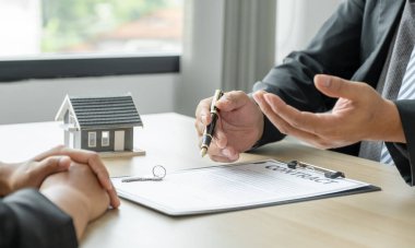 Emlakçının elinde kalem tutması ve iş sözleşmesini, kirayı, satın almayı, ipoteği, krediyi ya da ev sigortasını alıcıya açıklar..