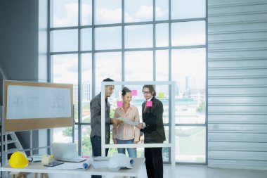 İnşaat planı çizimleri, çalışma planı ve inşaata başlamadan önce işleri dağıtmak için mühendis ekibi toplantısı.