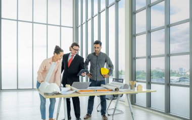 Engineer team is meeting to inspect the construction blueprint drawings, work plan and distribute work before starting the building.