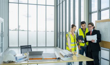 Engineer team is meeting to inspect the construction blueprint drawings, work plan and distribute work before starting the building.