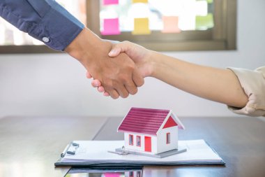 Emlakçılar ve alıcılar iş sözleşmesi imzaladıktan sonra el sıkışırlar, kira, satın alma, ipotek, kredi veya ev sigortası.