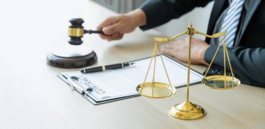 justice scale standing in front of the lawyer providing legal consult business dispute service at the office with gavel hammer.