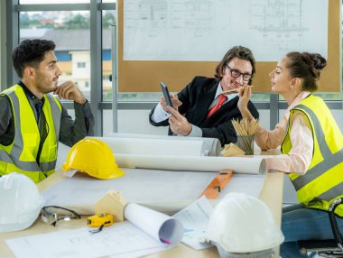 Engineer team is meeting to inspect the construction blueprint drawings, work plan and distribute work before starting the building.