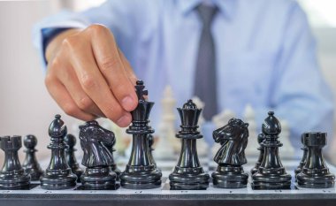 Satrancı kazanmak için strateji ve taktikle hareket ettirir, masa oyununda mücadele eder, iş fırsatı yarışması stratejik meydan okuma konsepti.