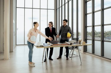Engineer team is meeting to inspect the construction blueprint drawings, work plan and distribute work before starting the building.