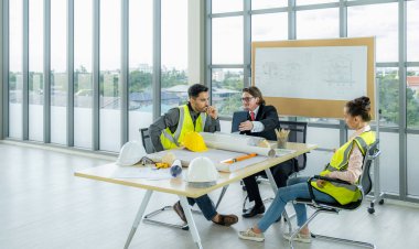 Engineer team is meeting to inspect the construction blueprint drawings, work plan and distribute work before starting the building.