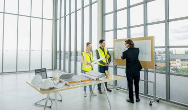 Engineer team is meeting to inspect the construction blueprint drawings, work plan and distribute work before starting the building.