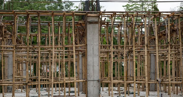 Geleneksel inşaat arka planında Bambu iskelesi ya da koltuk değnekleri.