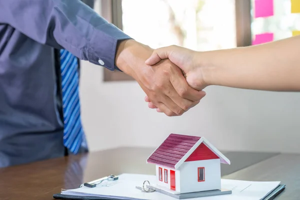 Real estate agents and buyers handshake after signing a business contract, renting, buying, mortgage, loan or home insurance.