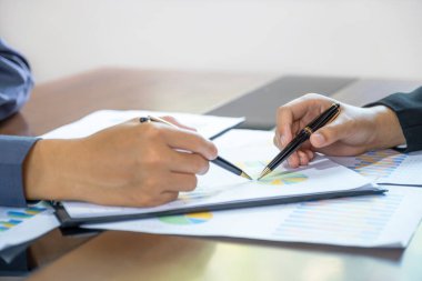 İş kadınları ve iş adamları iş gelirlerini artırmak için strateji planlamak üzere toplanıyorlar. Beyin fırtınası yapan bir finans grafik analizi yapın ve yeni hedef için tartışın..