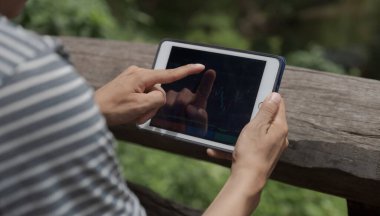 Tüccar el, hisse senedi grafiğini analiz eder ve tabletle rapor verir. Çevrimiçi Forex pazar yönetimi için hedefler belirler..