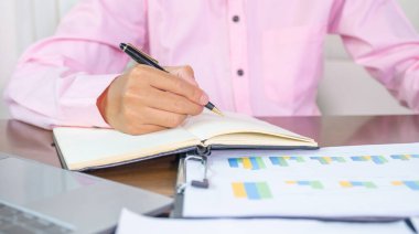 İş adamı muhasebeci elinde kalemle işyerinde vergi ödemeyi hesaplıyor..