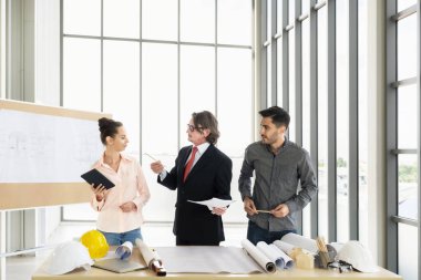 İnşaat planı çizimleri, çalışma planı ve inşaata başlamadan önce işleri dağıtmak için mühendis ekibi toplantısı.