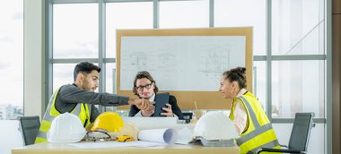 Engineer team is meeting to inspect the construction blueprint drawings, work plan and distribute work before starting the building.