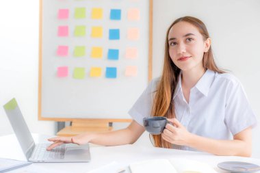 İş kadınları yönetimi kahve içiyor ve dizüstü bilgisayarlarla iş gelirlerini artırmak için stratejiler planlıyor. Çalışan bir finans grafik analizi yapın ve yeni hedefin başarısını tartışın.