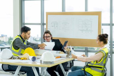 Engineer team is meeting to inspect the construction blueprint drawings, work plan and distribute work before starting the building.