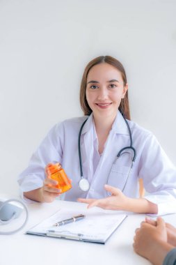 Doktorun el ele tutuştuğu ilaç şişeleri, tavsiye raporu sağlık muayenesi sonuçları ve hastalara, mesleki danışmanlık tıbbi kontrol programı konseptine ilaç öneriyor..