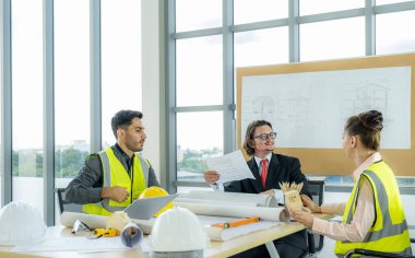 Engineer team is meeting to inspect the construction blueprint drawings, work plan and distribute work before starting the building.