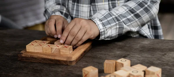 hands kid playing the wooden block game is a way to learn, and develop a way of thinking about concepts, potential and the brain.