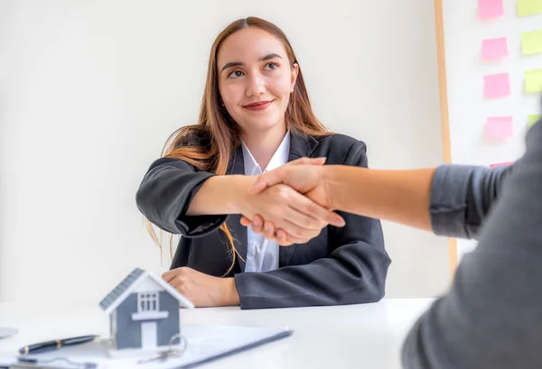 Real estate agents sale broker and buyers handshake after signing a business contract at home office, and discuss saving money for renting, buying mortgage loan, or financial house insurance.