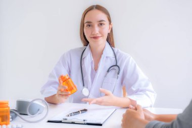 Doktorun el ele tutuştuğu ilaç şişeleri, tavsiye raporu sağlık muayenesi sonuçları ve hastalara, mesleki danışmanlık tıbbi kontrol programı konseptine ilaç öneriyor..