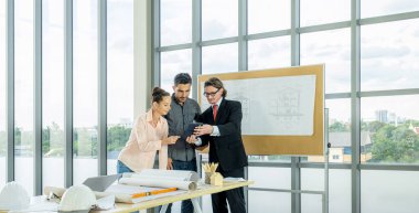 Engineer team is meeting to inspect the construction blueprint drawings, work plan and distribute work before starting the building.