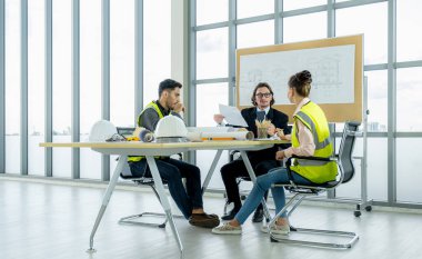 Engineer team is meeting to inspect the construction blueprint drawings, work plan and distribute work before starting the building.