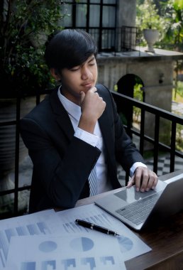 İş adamları muhasebeci hesap makinesi, dizüstü bilgisayar analizi kullanarak zorlu iş hedeflerini belirleme grafiğini ve merkez ofisindeki hedefe ulaşmaya hazır hale getiriyor..