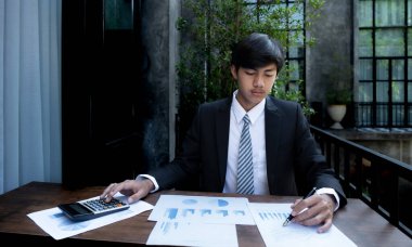 İş adamlarının elinde kalem tutan muhasebeci hesap makinesi ve dizüstü bilgisayar analizi zorlu iş hedefleri belirleme grafiği ve merkez ofisindeki hedefe ulaşmaya hazır.