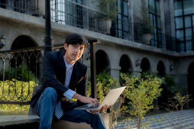 Başarılı iş adamı yatırımcılar, iş hedeflerini belirlemek ve açık hava otelinden hedeflere ulaşmak için internet ya da video üzerinden uzaktan iletişim kurmak için dizüstü bilgisayar kullanıyorlar..