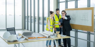 Engineer team is meeting to inspect the construction blueprint drawings, work plan and distribute work before starting the building.