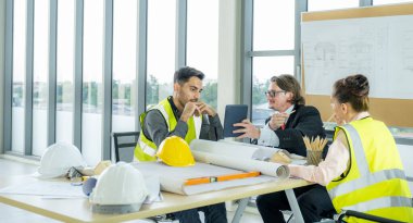 Engineer team is meeting to inspect the construction blueprint drawings, work plan and distribute work before starting the building.