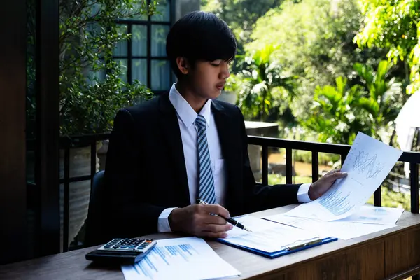 İş adamlarının elinde kalem tutan muhasebeci hesap makinesi ve dizüstü bilgisayar analizi zorlu iş hedefleri belirleme grafiği ve merkez ofisindeki hedefe ulaşmaya hazır.