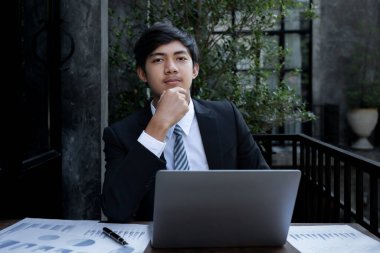 İş adamları muhasebeci hesap makinesi, dizüstü bilgisayar analizi kullanarak zorlu iş hedeflerini belirleme grafiğini ve merkez ofisindeki hedefe ulaşmaya hazır hale getiriyor..