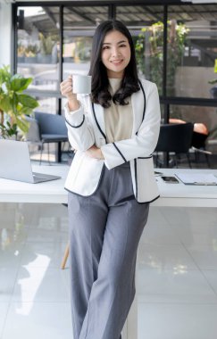 İş kadınları yönetimi kahve içiyor ve iş gelirlerini artırmak için stratejiler planlıyor. Çalışan bir finans grafik analizi yapın ve yeni hedefin başarısını tartışın.