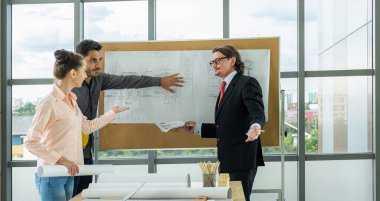 Engineer team is meeting to inspect the construction blueprint drawings, work plan and distribute work before starting the building.