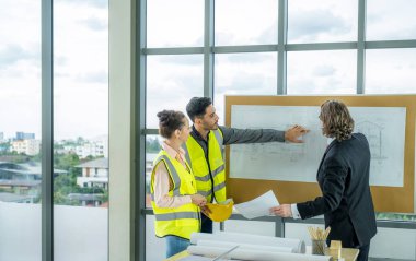 Engineer team is meeting to inspect the construction blueprint drawings, work plan and distribute work before starting the building,