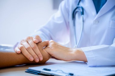 Doktor hastayı cesaretlendirmek için elini tuttu ve sağlık muayenesi sonuçlarını, sağlık kontrolü konseptini açıkladı..