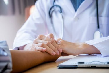 Doktor hastayı cesaretlendirmek için elini tuttu ve sağlık muayenesi sonuçlarını, sağlık kontrolü konseptini açıkladı..