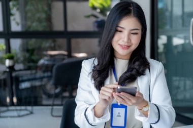 Başarılı iş kadını finansör yatırımcılar, iş hedeflerini belirlemek ve iş ofisinden hedeflere ulaşmak için internet veya video üzerinden uzaktan iletişim kurmak için akıllı telefon kullanıyorlar..