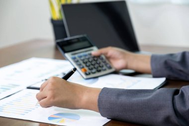 İş kadını ellerinin kalem tutması, iş hedeflerini belirlemek ve yeni hedefe ulaşmayı planlamak için merkez ofisteki bilgisayarı kullanarak grafiği analiz etmesi..