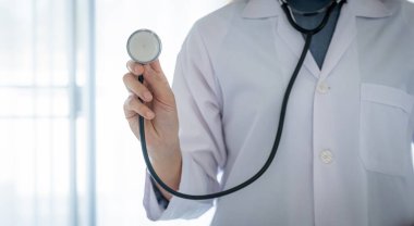 Doktor el steteskobu önünde beyaz bir arka plan sağlık konseptiyle tutuyor..