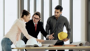 Engineer team is meeting to inspect the construction blueprint drawings, work plan and distribute work before starting the building.