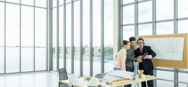 Engineer team is meeting to inspect the construction blueprint drawings, work plan and distribute work before starting the building.
