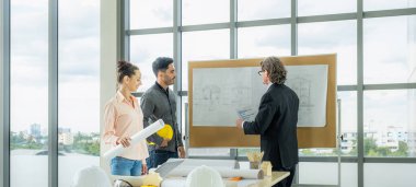 Engineer team is meeting to inspect the construction blueprint drawings, work plan and distribute work before starting the building.