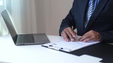 İcra kurulu başkanı iş başvurusu belgelerini kontrol eden işadamı özgeçmişleri, görüşmeleri ve ofis odasındaki sözleşmeyi onaylamak için imzaları atıyor..