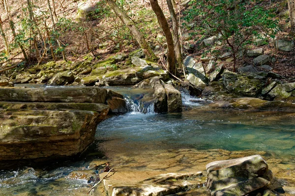 岩肌の間のターコイズブルーの小川に流れ落ちる透明な水 — ストック写真